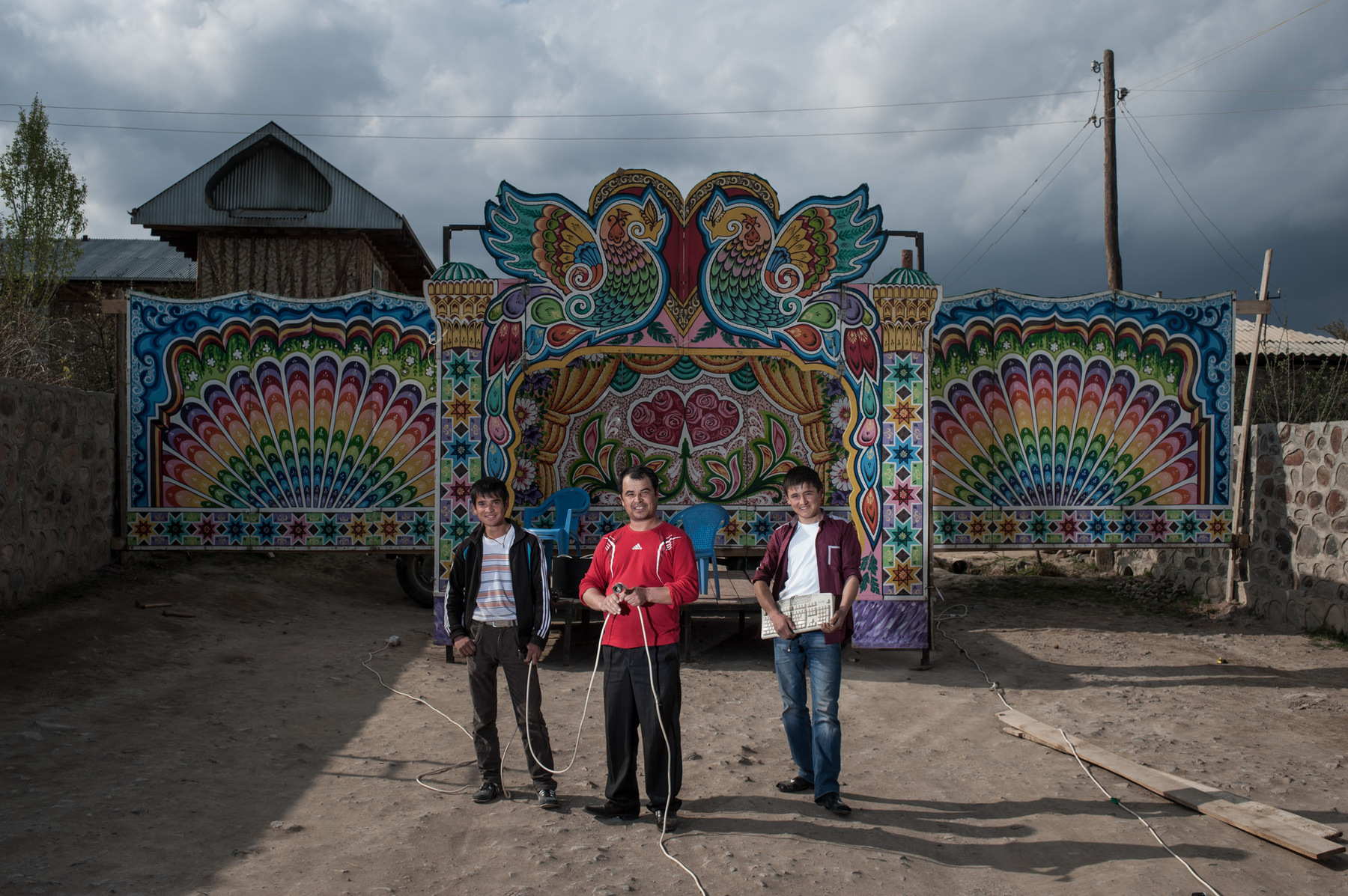 Konstantin Salomatin - 18 From left to right – Seyumbai Abdulaev, Muradjon Ergashev, Sherali Ahmadaliev. Muradjon is a sahna-owner. Sahna is a stage for brides and grooms on the background). Other men assist him. The rent of sahna costs 5000 roubles a day and it is his major business. He made the sahna himself. Tajikistan, Asht District, Markhamat village.